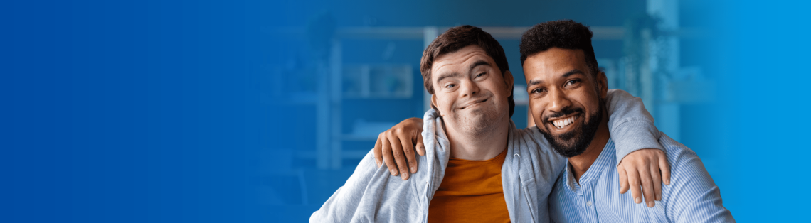 A young man with Down syndrome smiling with a friend